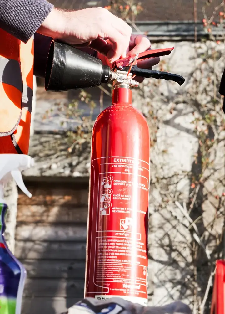 Professionnel installant un extincteur dans un environnement professionnel