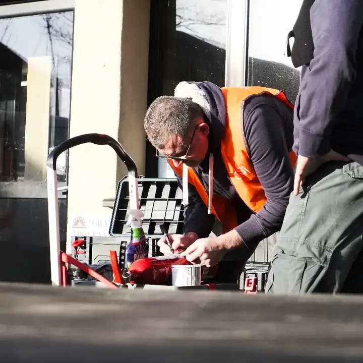 Technicien vérifiant un extincteur dans un environnement professionnel
